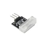 نمای نزدیک یک برد مدار مشکی ماژول سنسور مادون قرمز 22b78c86-9f30-461b-8542-d7328175fdaf با سه پین فلزی در یک طرف و یک جزء مستطیلی نیمه شفاف در طرف دیگر، در کنار ماژول آمپلی فایر 2x5W کلاس8406 PADless seam کلاس84 با تراشه P ادغام.